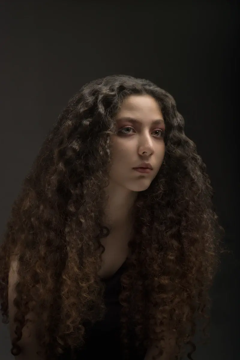 Mulher com cabelo cacheado, volumoso e comprido